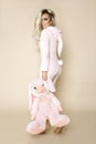 Beautiful blonde woman wearing a pajama, a bunny costume, smiling happily. Fashion model in Easter bun Royalty Free Stock Photo