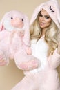 Beautiful blonde woman wearing a pajama, a bunny costume, smiling happily. Fashion model in Easter bun Royalty Free Stock Photo