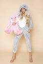 Beautiful blonde woman wearing a pajama, a bunny costume, smiling happily. Fashion model in Easter bun Royalty Free Stock Photo