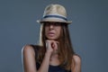 Beautiful sexy brunette woman in a fashion hat is posing stylishly isolated on gray background in a studio Royalty Free Stock Photo