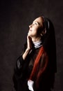 Beautiful catholic nun posing on a dark background. religious concept