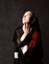 Beautiful catholic nun posing on a dark background. religious concept