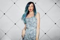 Beautiful celebrity girl posing for press photographers. Elegant dress, long hair dyed blue.