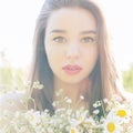 Beautiful cute girl with big lips and red lipstick with bared shoulders with a bouquet of daisies at sunset on a sunny warm Royalty Free Stock Photo