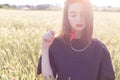 Beautiful cute girl with big lips and red lipstick in a black jacket with a flower poppy standing in a poppy field at sunset Royalty Free Stock Photo