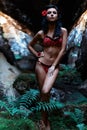 Beautiful cute girl with black hair in a wet bathing suit with a flower in her hair and a ring on his finger in the dark rain Royalty Free Stock Photo