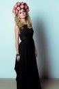 Beautiful cute girl blonde in black fashion long dress and with a wreath on his head in the Studio with bright makeup Smokey Royalty Free Stock Photo