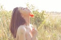 Beautiful cute woman with bare shoulders holding poppy flowers in his hands at sunset on a sunny summer day Royalty Free Stock Photo