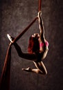 Beautiful dancer on aerial silk, graceful contortion, acrobat performs a trick on a ribbons Royalty Free Stock Photo