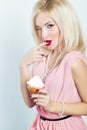 Beautiful elegant blonde woman with bright makeup in pink dress in the Studio on a white background sitting with a cupcake Royalty Free Stock Photo