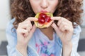 Beautiful girl with dark curly hair, eating a bright juicy fruit cake with a big appetite