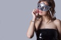 Beautiful girl with full lips in black leather dress wore a gray mask , festive image Royalty Free Stock Photo