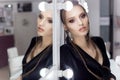 Beautiful girl with hair in the style of rock stands near the mirror in the dressing room in a black velvet gown with a brigh Royalty Free Stock Photo