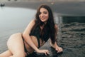 Beautiful girl with long hair lying on beach with black sand. Young woman enjoys relaxing near ocean Royalty Free Stock Photo