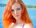 Beautiful girl with red hair and bikini posing on a beach Royalty Free Stock Photo