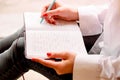 Beautiful sexy girl sits on a windowsill with a notebook and thinks. Details close up. A lonely woman in a man shirt reads a book,