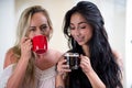 Beautiful lesbians lovers at morning, blonde and brunette girls are drinking coffee, in a white background