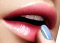 Beautiful lips with magenta lip gloss makeup. Shiny lipgloss, lips care, moistening, balm.