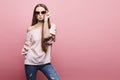 Beautiful and sexy model blonde girl in a blouse with naked shoulders and in fashionable pink sunglasses sending air