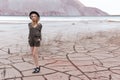 Beautiful slender girl in a black hat in the mountains with a strong wind