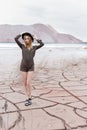 Beautiful slender girl in a black hat in the mountains with a strong wind Royalty Free Stock Photo