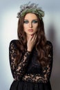 Beautiful slim elegant woman with bright makeup Smoky Eyes in the New Year wreath of Christmas tree and cones