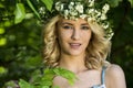 Beautiful smiling girl with a wreath on his head in the spring park Royalty Free Stock Photo