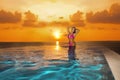 Beautiful sexy tanned woman bikini model on Maldives at sunset. Young glamour girl in swimsuit in pool. Perfect body bikini model Royalty Free Stock Photo