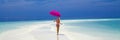 Beautiful sexy tanned woman bikini model with pink umbrella on Maldives island. Young glamour girl in swimsuit on Maldives Royalty Free Stock Photo