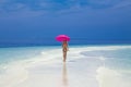 Beautiful sexy tanned woman bikini model with pink umbrella on Maldives island. Young glamour girl in swimsuit on Maldives Royalty Free Stock Photo