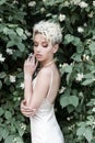 Beautiful tender girl with short haircut in cream dress with jasmine flower