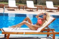 Beautiful woman bikini model tanned and lying on deck chair Royalty Free Stock Photo