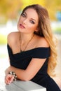 Beautiful woman with black dress and blond hair outdoor. Fashion girl Royalty Free Stock Photo