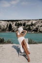 Beautiful sexy woman with dark hair with bath towels on body and head posing near lake and mountains Royalty Free Stock Photo