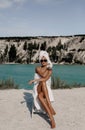 Beautiful sexy woman with dark hair with bath towels on body and head posing near lake and mountains Royalty Free Stock Photo