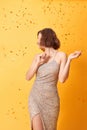 Beautiful sexy woman in evening dress celebrating, golden confetti, party, smiling, inviting, happy Royalty Free Stock Photo