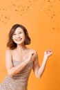 Beautiful sexy woman in evening dress celebrating, golden confetti, party, smiling, inviting, happy Royalty Free Stock Photo