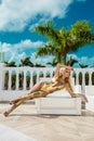 Beautiful sexy woman in gold bikini and gold shoes posing on the caribbean luxury hotel Royalty Free Stock Photo