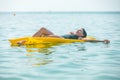 beautiful sexy woman laying on yellow inflatable mattress at sea water Royalty Free Stock Photo