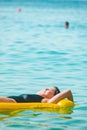 beautiful sexy woman laying on yellow inflatable mattress at sea water Royalty Free Stock Photo