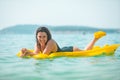 beautiful sexy woman laying on yellow inflatable mattress at sea water Royalty Free Stock Photo