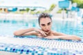 Beautiful sexy woman relaxing in swimming pool water. Girl with healthy tanned skin, gorgeous face and wet hair enjoying summer Royalty Free Stock Photo