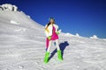 Beautiful sexy woman is wearing white fur, winter hat, scarf and winter boots. Attractive young girl in mountains Royalty Free Stock Photo