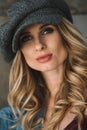 Beautiful sexy woman young girl with full lips and curls in a denim jacket and felt cap . Soft selective focus Royalty Free Stock Photo