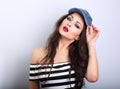 Beautiful young make-up model holding fashion blue cap and Royalty Free Stock Photo