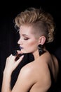 Beautiful young woman with blond hair with a short haircut with bright makeup and fashion bizhuterieyker earrings and ring, f