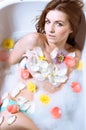 Beautiful young woman having bath with flower petals Royalty Free Stock Photo