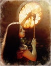 Beautiful shamanic girl playing on shaman frame drum in the nature, old photo effect. Royalty Free Stock Photo