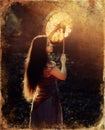 Beautiful shamanic girl playing on shaman frame drum in the nature, old photo effect Royalty Free Stock Photo