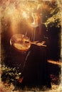 Beautiful shamanic girl playing on shaman frame drum in the nature, old photo effect Royalty Free Stock Photo